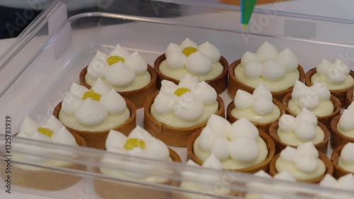 Confectioner decorating bisquits with orange jam close up shot