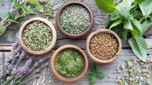 An assortment of herbs in terracotta bowls on a wooden surface, complemented by fresh greens and sprigs of lavender, showcasing natural ingredients.