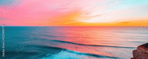 A stunning sunset casts vibrant hues over calm ocean waves, creating a serene and picturesque coastal scene.