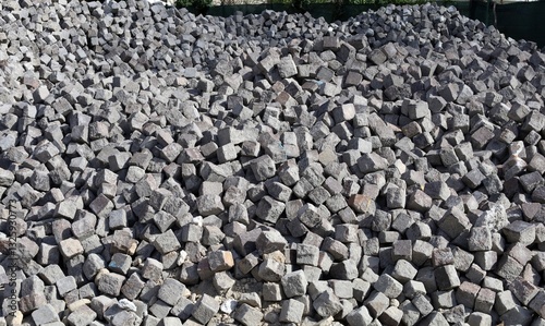 Large heap of porphyry cubes. They are used as construction materials for pavement. Background and texture.