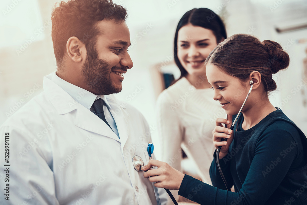 Indian doctor seeing patients in office. Daughter is using stethoscope on doctor. Indian doctor seeing patients in office. Daughter is using stethoscope on doctor.