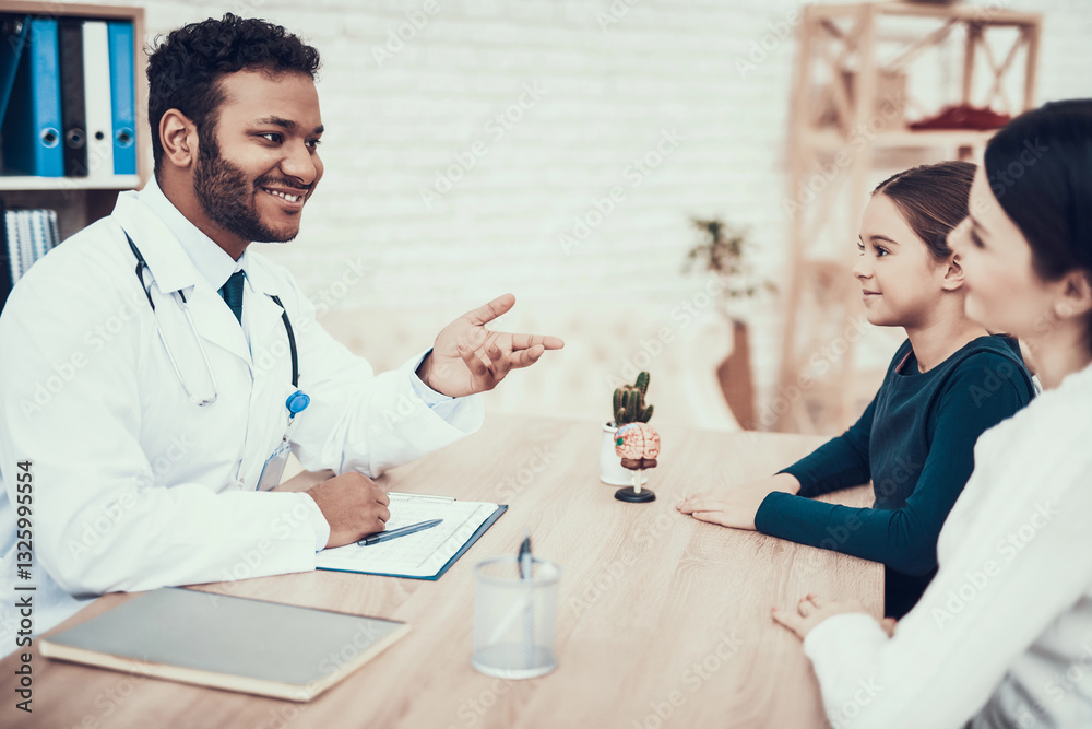 Fototapeta premium Indian doctor seeing patients in office. Mother and daughter are listening to doctor.