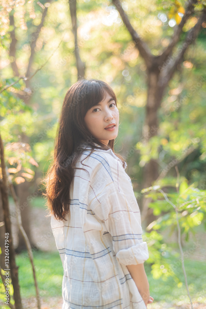 Asian woman enjoying summer outdoors, breathing fresh air in serene forest, surrounded by sunlight and greenery, feeling relaxed Asian woman enjoying summer outdoors, breathing fresh air in serene forest, surrounded by sunlight and greenery, feeling relaxed