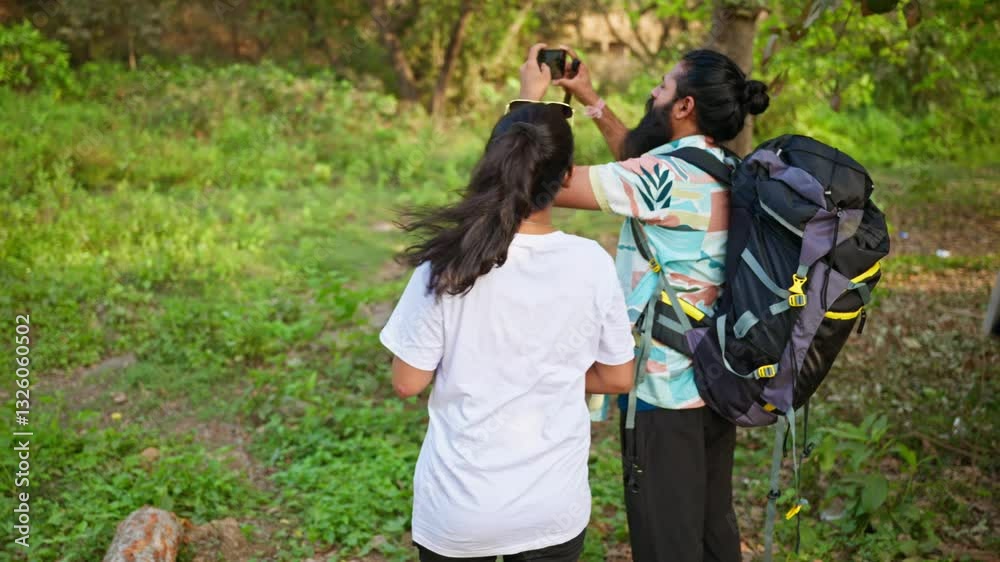 Two hikers shake hands as buyer clicks land photo outdoors