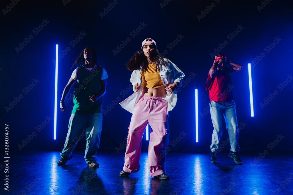 Fototapeta premium Group of hip hop dancer dancing together in a moody studio with tube neon lights.