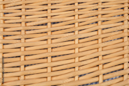 A close-up shot of woven rattan with a visible underlying fabric, creating a textured pattern