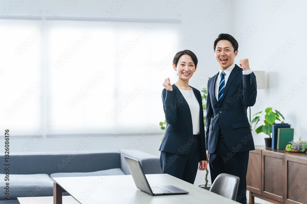 Fototapeta premium オフィスでガッツポーズする男女ビジネスパーソンのグループ