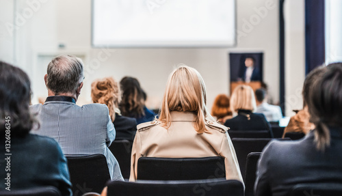 Speaker giving a talk in conference hall at business event. Rear view of unrecognizable people in audience at the conference hall. Business and entrepreneurship concept