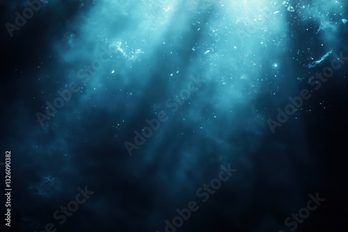 Underwater low-angle shot of sunlight rays shining through dark ocean; concept, mysterious, deep sea, abstract, nature.