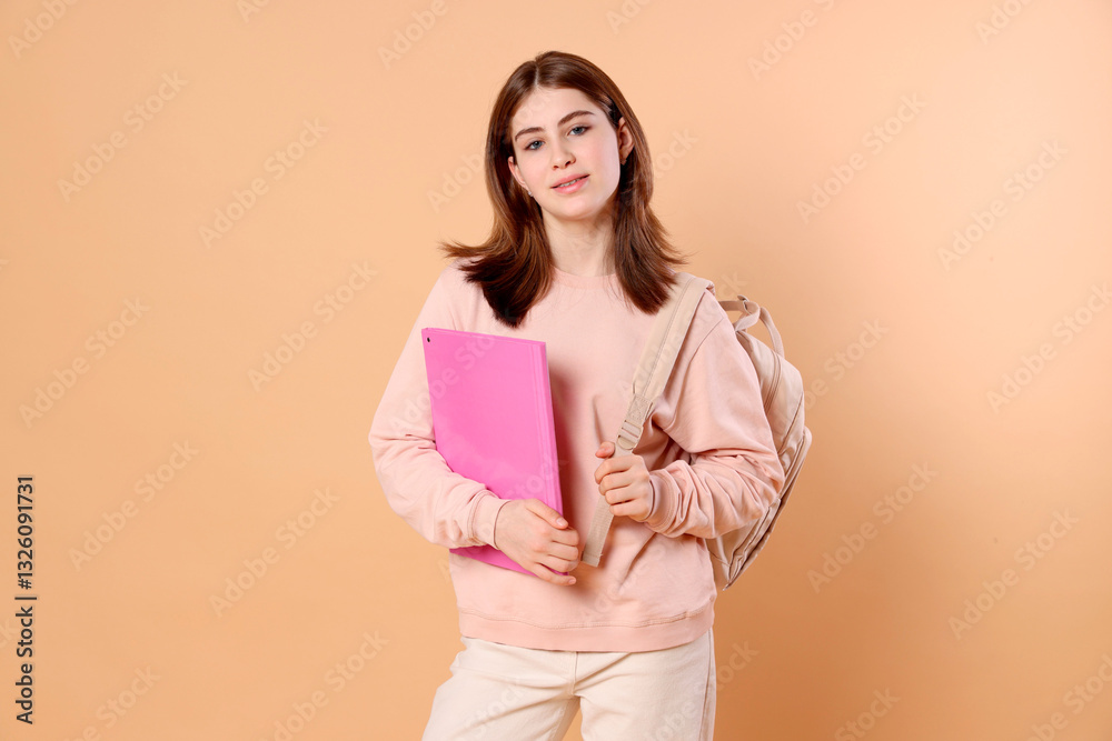 Portrait of teenage girl with backpack and folder on beige background