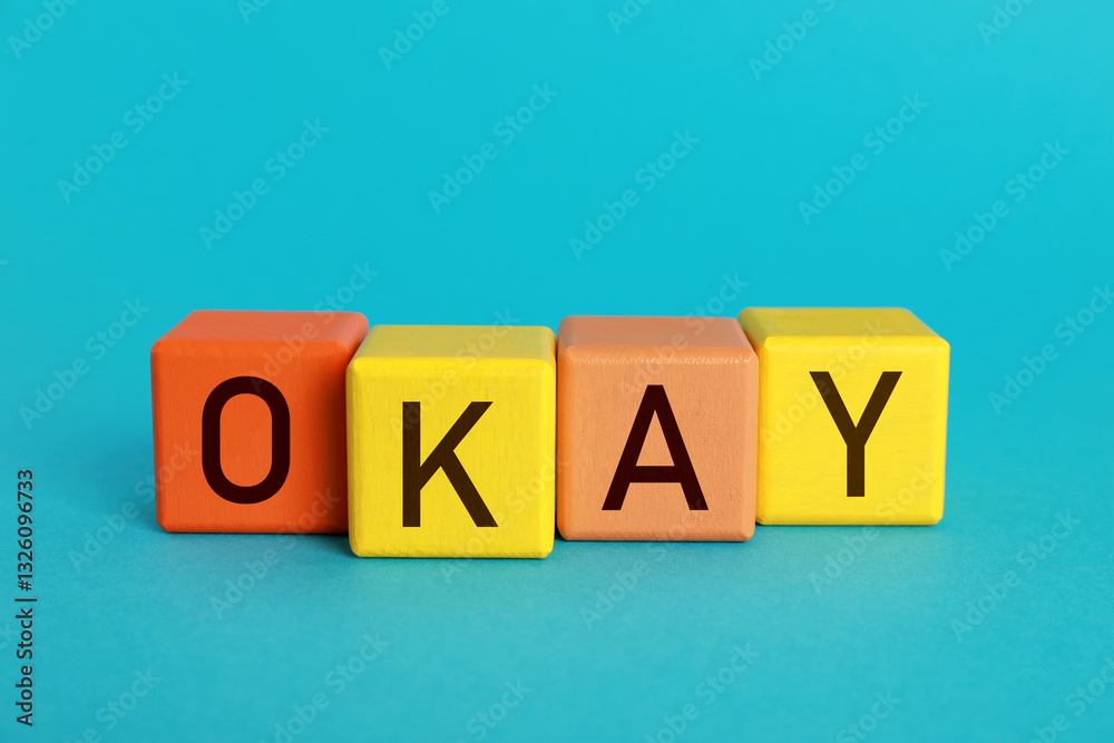 Obraz premium Colorful cubes with word Okay on light blue background