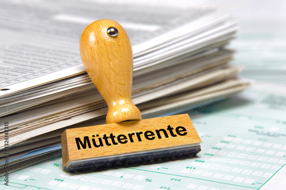 Ein Holzstempel mit der Aufschrift Mütterrente steht auf einem Formular