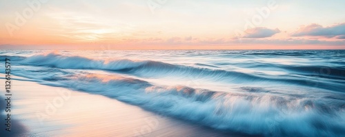 The ocean waves crashing gently on the sandy beach at sunset