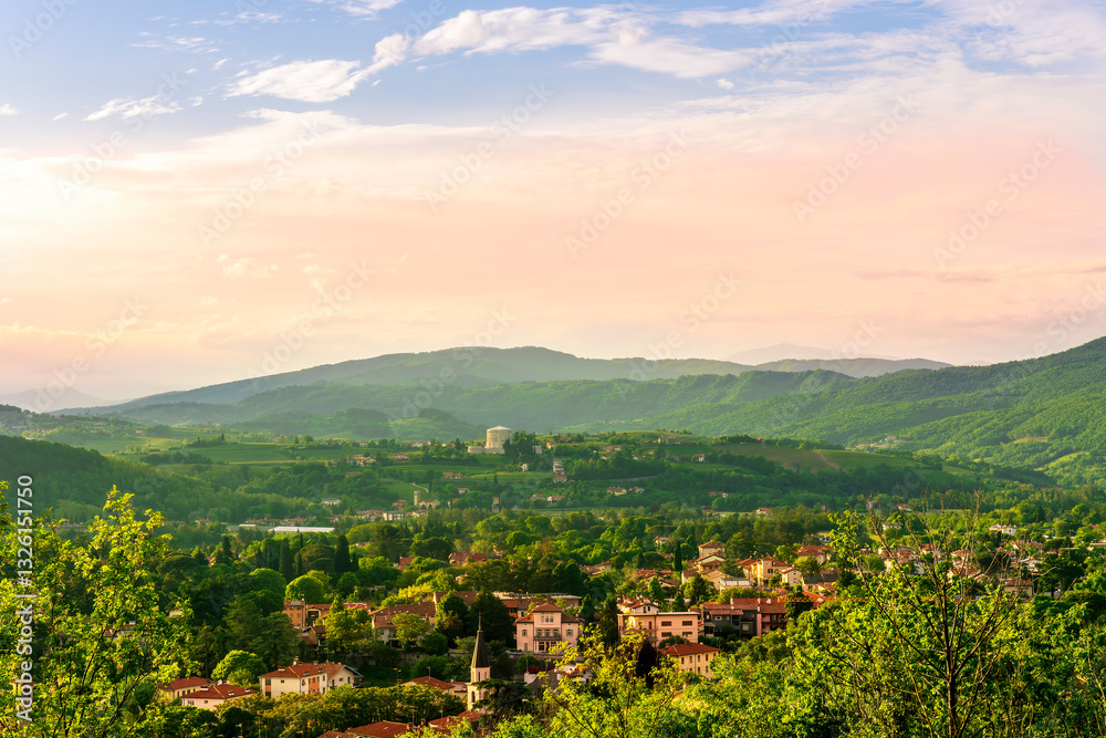 Naklejka premium travel summer view from hill to a nice european town with amazing buildings, green hills and mountains with amazing cloudy evening sky on background