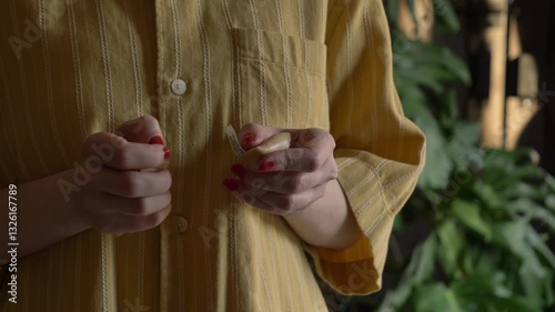 woman opening fortune cookie at home, closeup view
