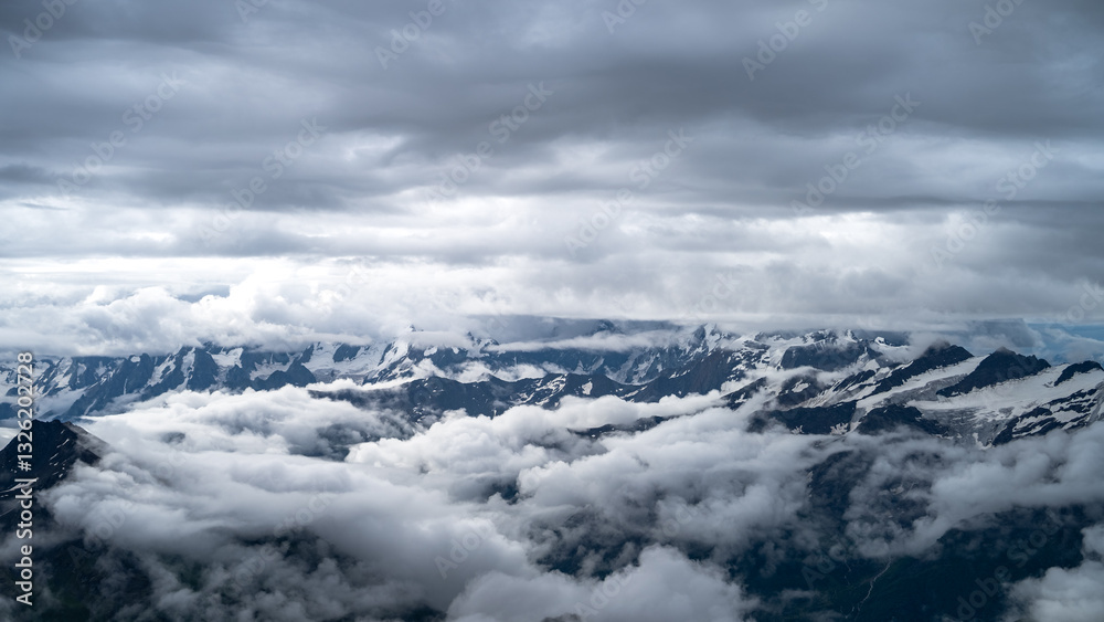 Fototapeta premium snowy mountain peaks in the clouds