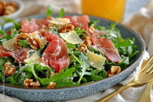 Fresh Arugula Salad Topped With Prosciutto and Walnuts Served at a Modern Din...