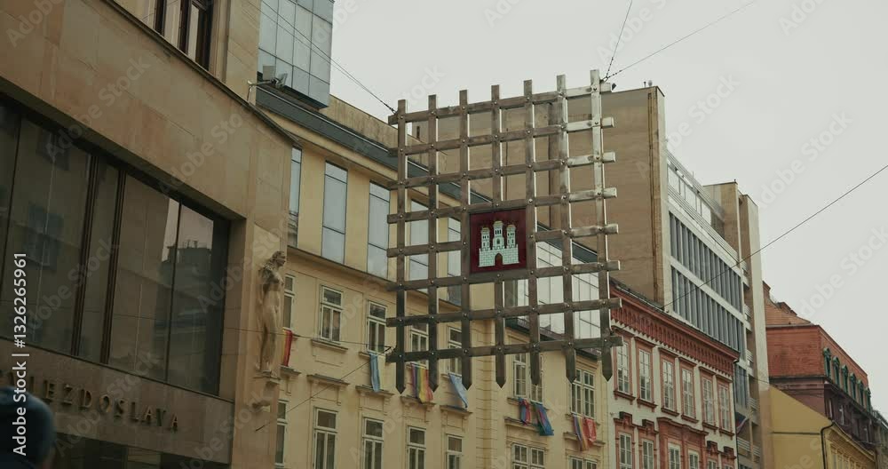 Bratislava city emblem displayed on a suspended metal grid in an urban setting Bratislava city emblem displayed on a suspended metal grid in an urban setting