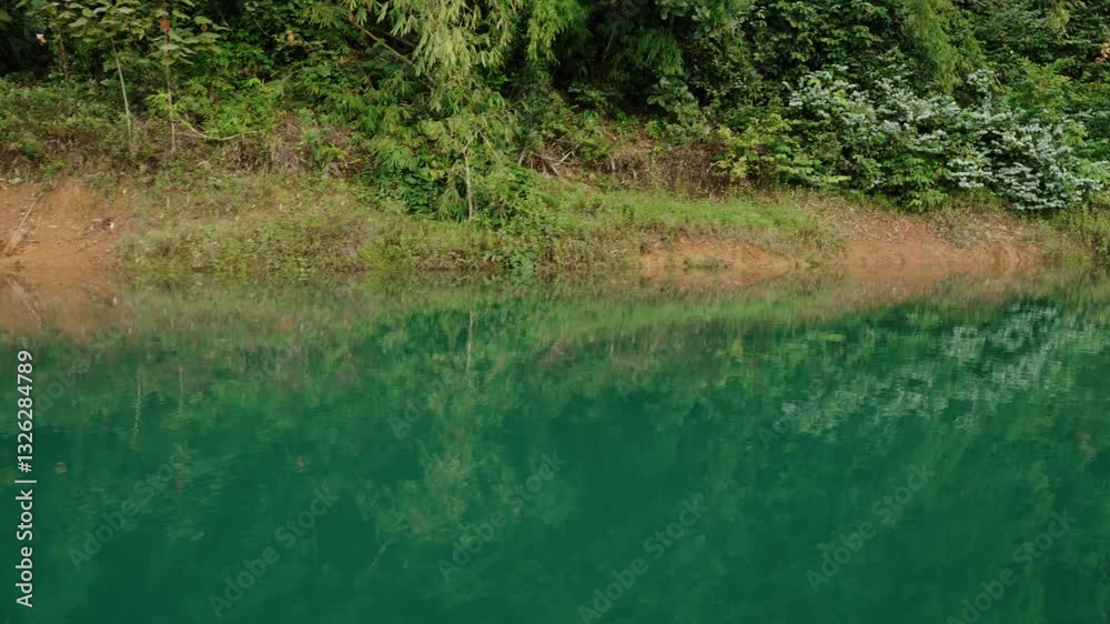 Sailing Along The Calm Green Water Of Lake Along The Forest In Khao Sok National Park In Thailand. - POV shot Sailing Along The Calm Green Water Of Lake Along The Forest In Khao Sok National Park In Thailand. - POV shot