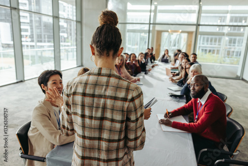 Fotografie Female leader conducting workshop with professionals in modern office setting, f