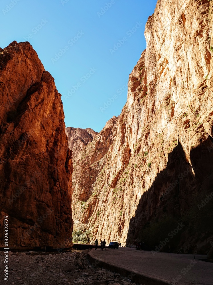 Scenic mountain gorge with steep rocky cliffs under a clear blue sky in Todra Gorge, Morocco
