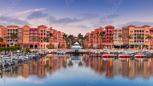 Naples, Florida, USA. Cityscape image of Naples, Florida with reflection of the city skyline in the water at beautiful sunrise.