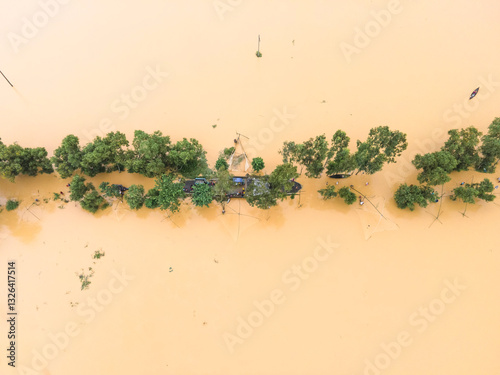 Aerial view of a flooded village with submerged houses and a road surrounded by trees, Jhenaigati, Sherpur, Bangladesh. photo