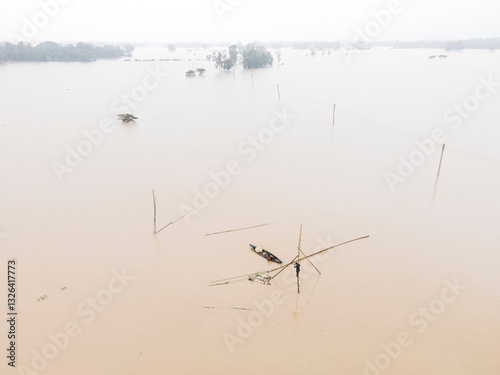 Aerial view of flooded village with submerged houses and overflowing water, Jhenaigati, Sherpur, Bangladesh.