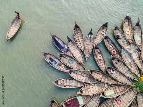 Aerial view of colorful boats on the Buriganga River with workers commuting in a bustling urban setting, Dhaka, Bangladesh. photo