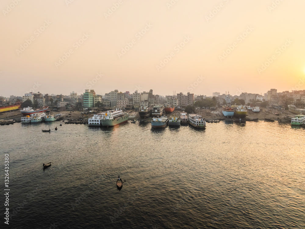 Aerial view of Sadar Ghat with bustling boats on the Buriganga River at sunset, Subhadya, Keraniganj, Dhaka, Bangladesh. Aerial view of Sadar Ghat with bustling boats on the Buriganga River at sunset, Subhadya, Keraniganj, Dhaka, Bangladesh.