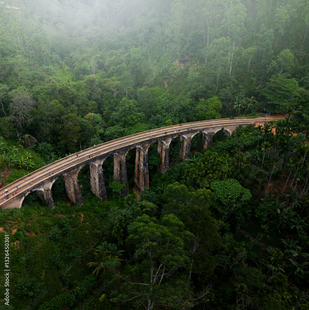 Aerial view of the historic 9 Arches Bridge surrounded by lush green forest and natural landscape, Gotuwela, Badulla District, Sri Lanka. Aerial view of the historic 9 Arches Bridge surrounded by lush green forest and natural landscape, Gotuwela, Badulla District, Sri Lanka.