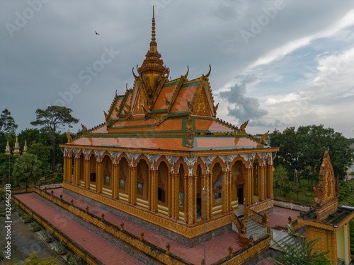 Aerial view of an ornate buddhist temple surrounded by trees under a cloudy sky, Tra Vinh, Tra Vinh, Vietnam. photo