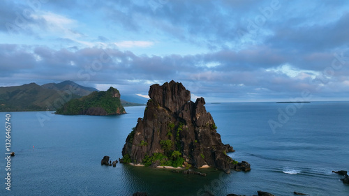 Aerial view of tranquil ocean with dramatic sea stack and majestic mountains, Hienghene, North Province, New Caledonia. photo