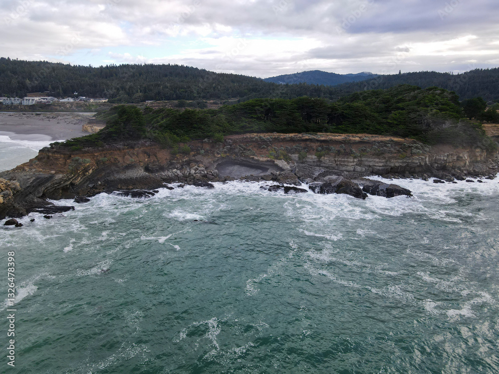 Aerial view of rugged coastline with rocky shore and crashing waves, The Sea Ranch, California, United States. Aerial view of rugged coastline with rocky shore and crashing waves, The Sea Ranch, California, United States.