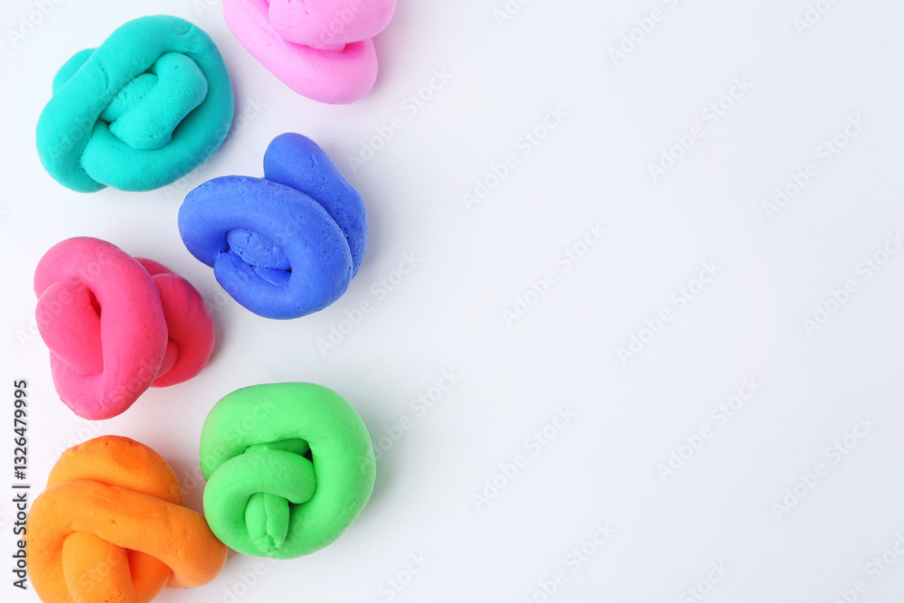 Naklejka premium Different colorful play dough on white background, flat lay. Space for text