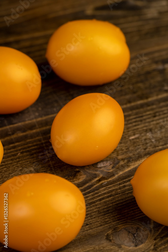 a large number of ripe orange tomatoes that are on the table