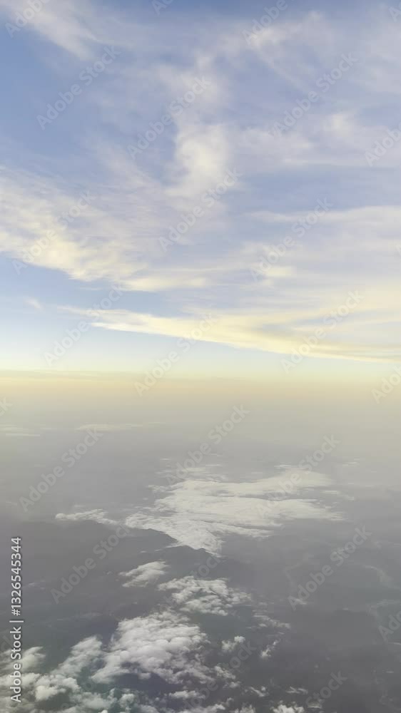 a serene aerial view of the sky with soft clouds below and a gradient of pastel colors at the horizon during sunset. a serene aerial view of the sky with soft clouds below and a gradient of pastel colors at the horizon during sunset.