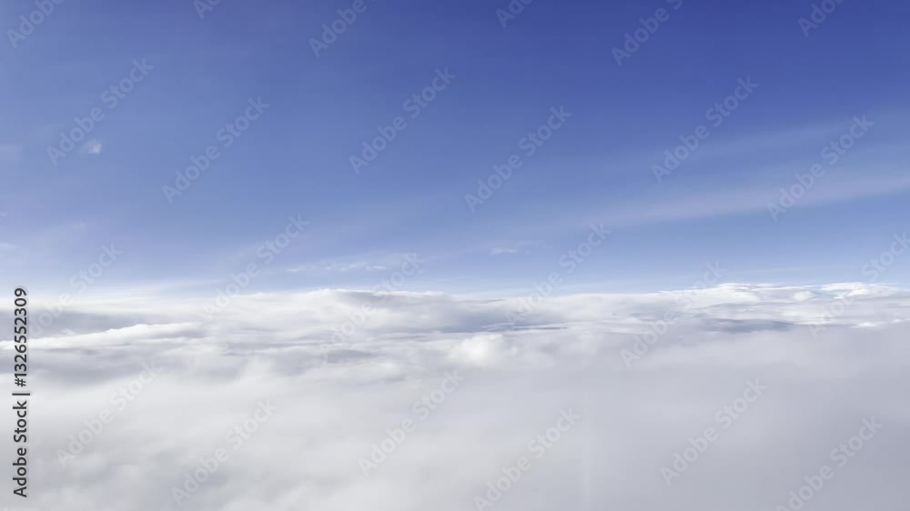 a dynamic aerial view of the sky, filled with layers of soft, billowing clouds. The upper portion reveals glimpses of a vibrant blue sky, contrasting with the denser, grayish-white clouds below. a dynamic aerial view of the sky, filled with layers of soft, billowing clouds. The upper portion reveals glimpses of a vibrant blue sky, contrasting with the denser, grayish-white clouds below.