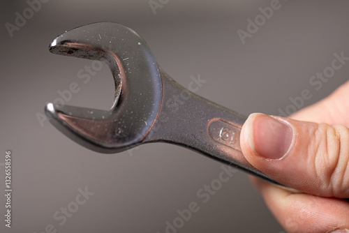 A well-used wrench held in ...