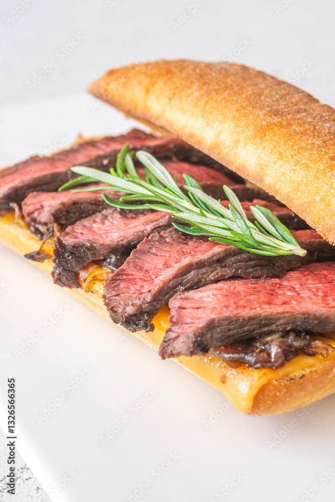 Grilled ciabatta sandwich with melted cheese, juicy steak, caramelized onions, and rosemary Grilled ciabatta sandwich with melted cheese, juicy steak, caramelized onions, and rosemary