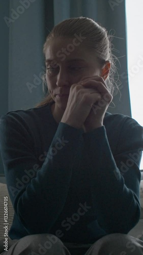 Vertical view from below of depressed Caucasian young woman listening to psychologist and thinking about her problem during consultation