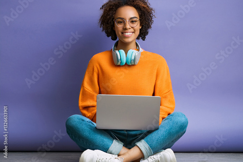 Happy woman working on a laptop while listening to music.