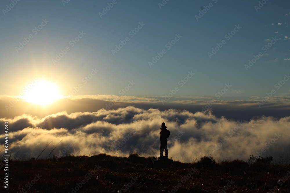 Fototapeta premium silhueta de homem caminhando em montanha com mar de nuvens ao fundo - foto tirada em santa catarina, na serra do rio do rastro