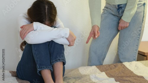 Mother rebuking daughter for bad behavior. Crying kid girl with mom scolding her on background. Child having bad mood and feeling upset. Family punishment concept