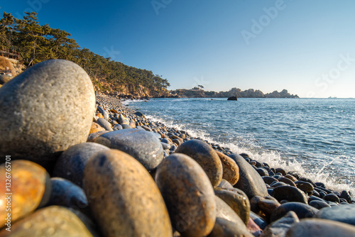 Beach in Korea with round rocks on the shore and small waves hitting them