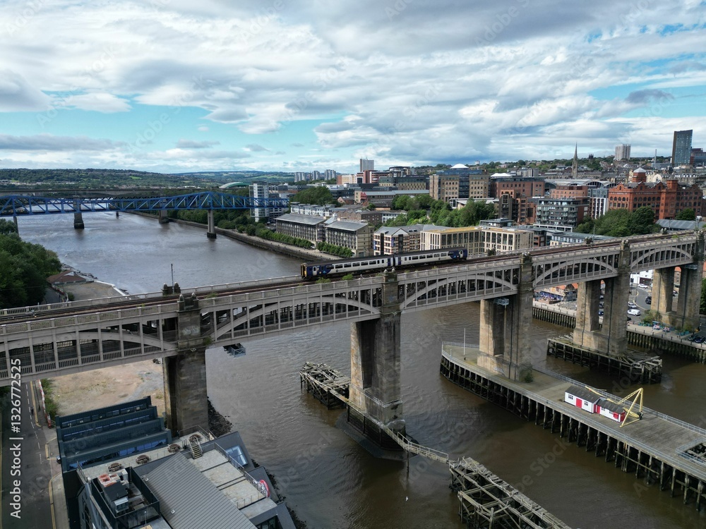 Fototapeta premium Aerial view of Newcastle upon Tyne featuring a train crossing the iconic High Level Bridge