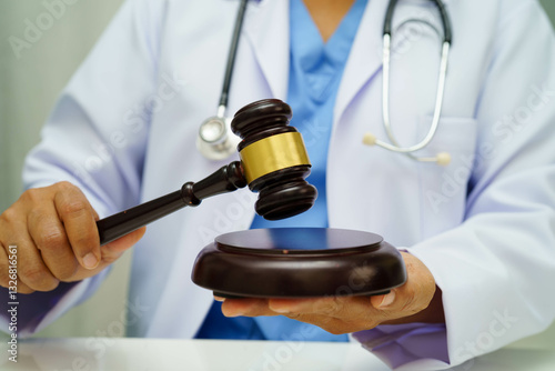 Asian doctor holding court hammer for and crime law justice, forensic medicine.