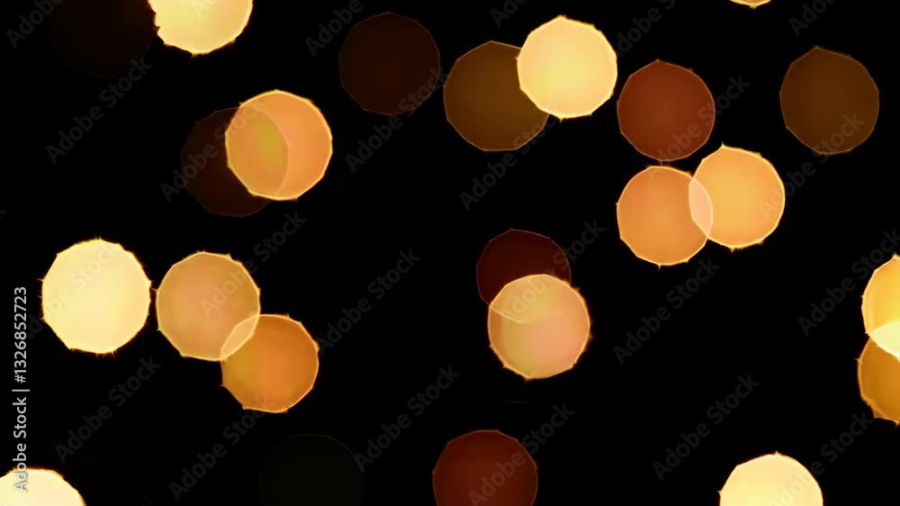 Warm glowing bokeh lights shimmer against dark background in gentle motion