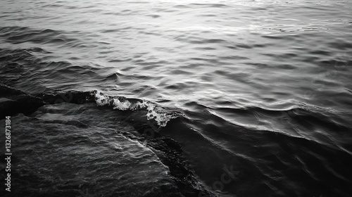 Calm black and white photography showcasing gentle waves lapping at rocky shorelines : Generative AI