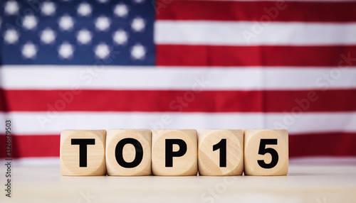 Wooden cubes with text TOP 15 on table in front of blurred American flag. The USA. Minimalist design photo